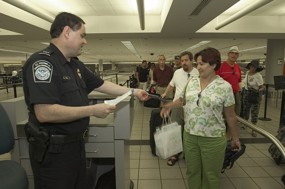 A CBP officer checks a passenger's documentation after arriving to the U.S.